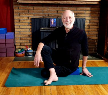 Will Doran, the Yoga Coach, seated in a twisted yoga pose